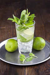 Mojito glass with mint leafs on the wooden desk.