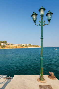 Lantern on pier in Nea Fokia, Greece.