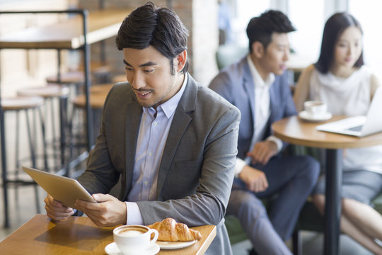 Businessman using digital tablet in caf_