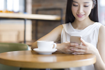 Young woman using smart phone in caf_