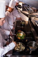 Group of chef preparing food in the kitchen