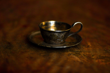steel cup and saucer on the old dark background