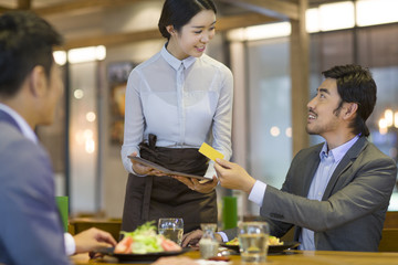 Businessman paying bill by credit card in restaurant