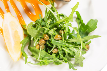 Arugula with capers on apricot mousse.