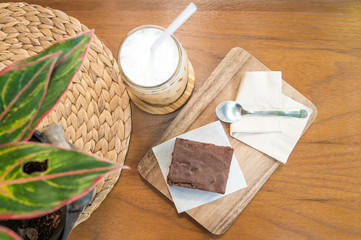Delicious ice coffee and  Chocolate Brownie on wooden tray