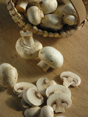 Mushrooms in basket and some on a cutting board sliced