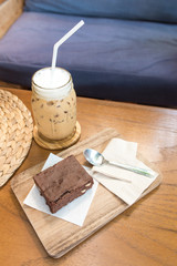 Delicious ice coffee and  Chocolate Brownie on wooden tray