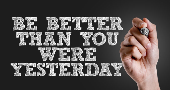 Hand writing the text: Be Better Than You Were Yesterday