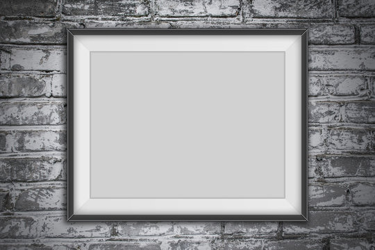 Empty photo frame on gray brick wall background.