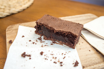 Bitten delicious Chocolate Brownie on wooden tray