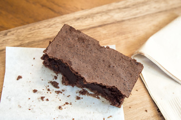 Bitten delicious Chocolate Brownie on wooden tray