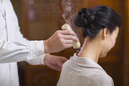 Senior Chinese doctor giving moxibustion