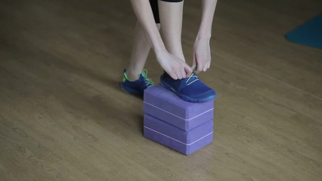 Girl tying shoelaces in the gym