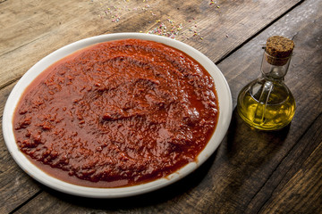 piatto di salsa al pomodoro con oliera su tavolo di legno