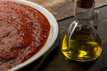 piatto di salsa al pomodoro con oliera su tavolo di legno