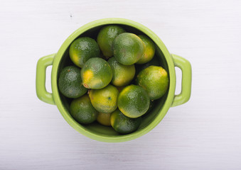 A green lemons on the bowl