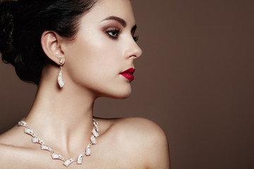 Naklejka premium Fashion portrait of young beautiful woman with jewelry. Brunette girl. Perfect make-up. Beauty style woman with diamond accessories