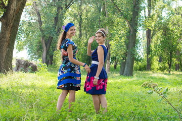  Two beautiful young woman relaxing outdoor. Two girls walking in park. two happy girls in the park for a walk, slight blur.
