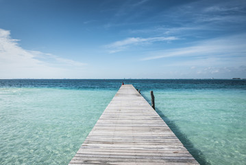 Fototapeta premium drewniany pomost do błękitnego tropikalnego morza w Isla Mujeres na Jukatanie w Meksyku