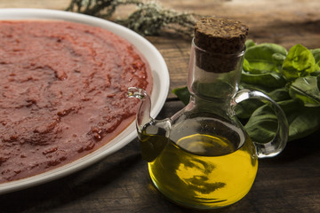 Piatto di salsa di pomodoro con olio di qualità  Italiano e ingredienti, su tavolo in legno
