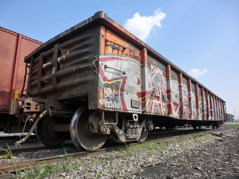 Urban train in rail yard with tracks and graffiti - landscape color photo