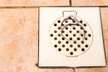 Bunch of hair trapped at bathroom shower drain outlet