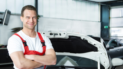 Car mechanic in a garage looking at repair costs