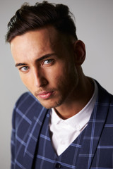 Close-up portrait of inquisitive young man wearing a suit