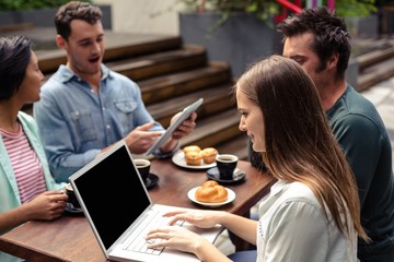 Smiling woman using laptop at the bar