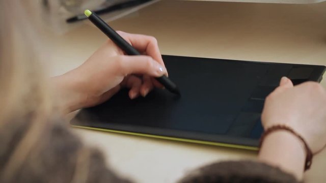 designer draws on graphic tablet close up