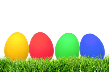 Row of Easter eggs on grass with a white background