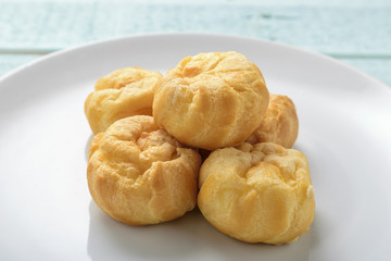 Eclair in a dish on a wooden background