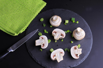 Champignon mushrooms on black background. Cooking, Healthy eating concept.