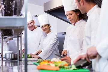 Fototapeta na wymiar Team of chefs chopping vegetables