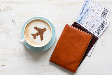 Aircraft made ofcinnamon in cappuccino, passports and boarding passes on white background. Travel concept