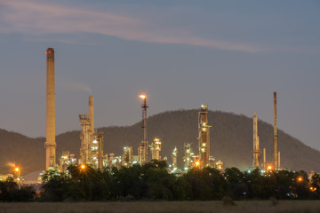 Petrochemical plant behind bush during twilight time