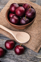 Plum jam and fruits on wooden background
