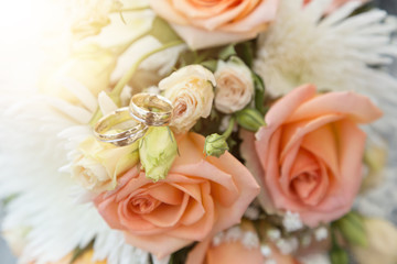 wedding rings on a bouquet of rouses