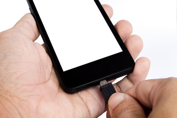 human's hand holding smart phone is charging on white background
