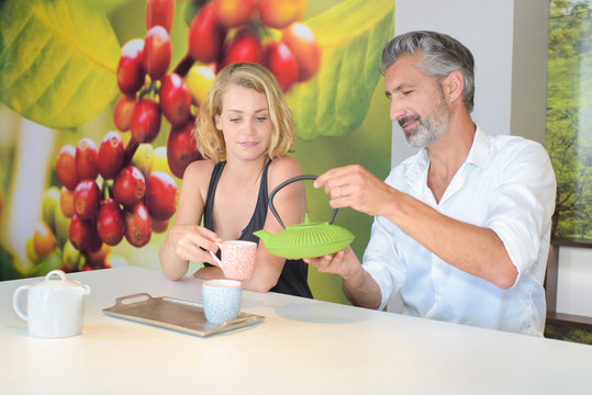 Man Pouring Hot Drink For Companion