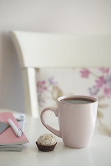 Напиток в розовой кружке и маленький десерт