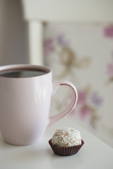 Напиток в розовой кружке и маленький десерт