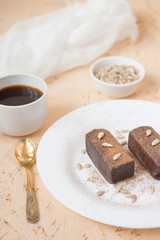 Chocolate dessert, coffee, sunflower seeds, white tableware.