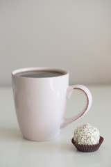 Напиток в розовой кружке и маленький десерт