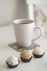 Напиток в розовой кружке и маленький десерт