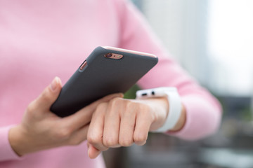 Woman using mobile phone and smart watch