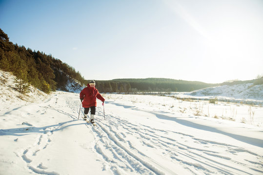 Caucasian woman cross-country skiing in snowy field