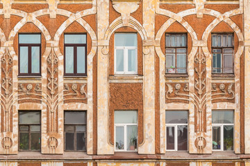 Several windows in row on facade of urban apartment building front view, St. Petersburg, Russia. © dr_verner