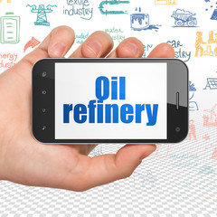 Manufacuring concept: Hand Holding Smartphone with Oil Refinery on display