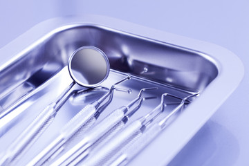 Professional dental tray with tools on blue background